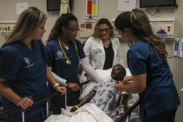 四名护士在医疗模拟模型上练习程序